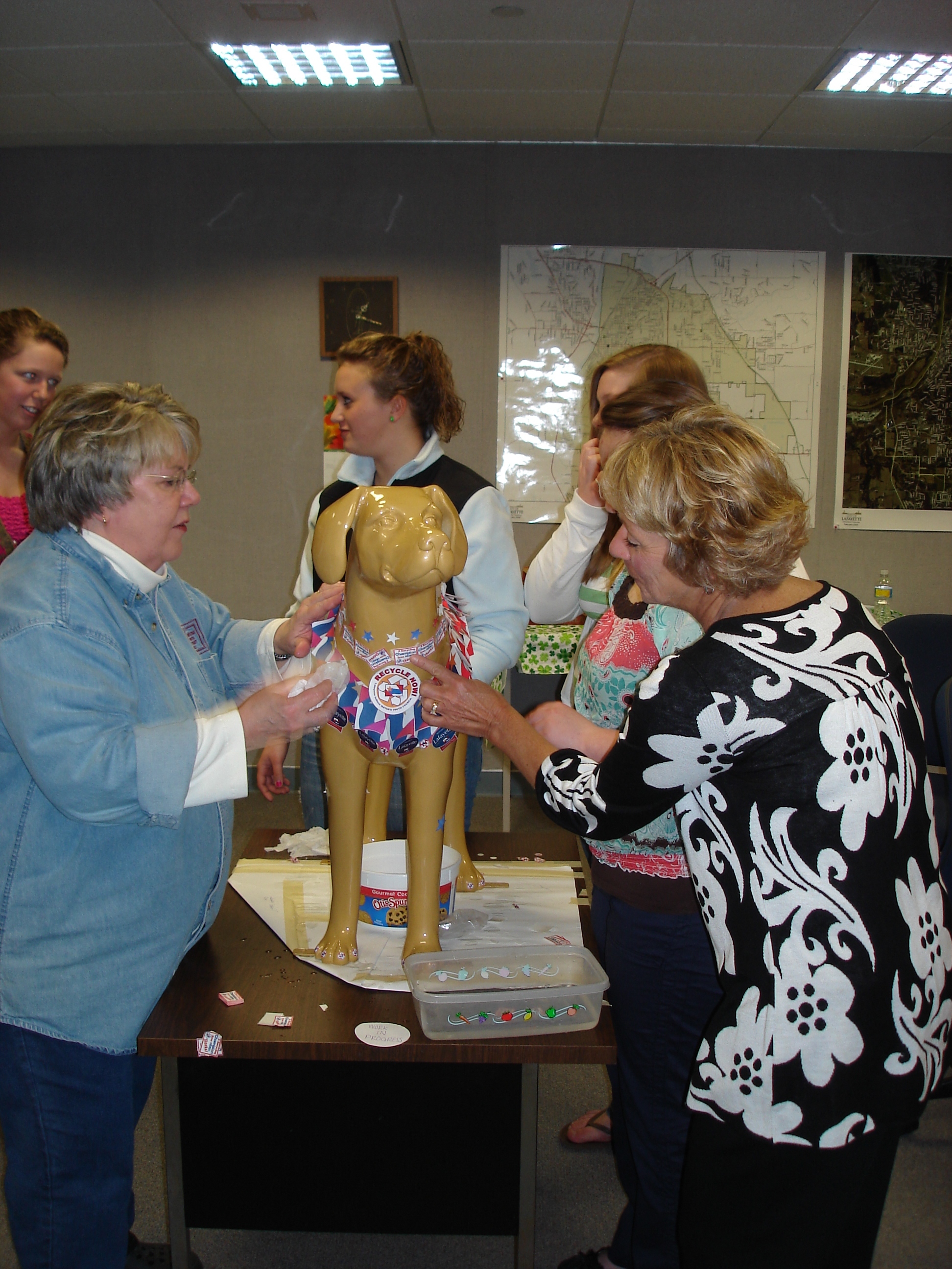Adults and teens decorating a fake dog